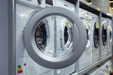 Bir ev aletleri dükkanında çamaşır makinesinin kapısını aç..