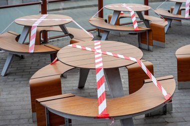 Açık kafe / restoran, koronavirüs salgını sırasında karantinaya alınmıştır. Restorana girmek yasak, kafeye girmek salgın süresince yasak, koltuklar uyarı bandıyla kapatılmış.