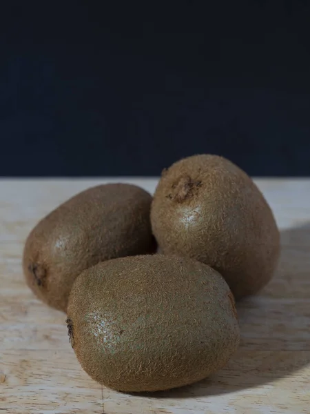 Üç koca kivi ahşap bir büfede kullanım efektiyle yatıyor.