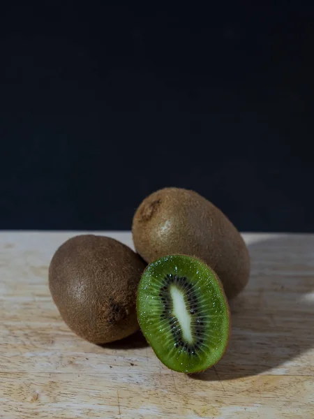 Vertical Photo Two Whole One Half Kiwis Lying Top Wooden — Stock Photo, Image
