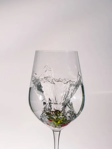 果物を落下させ 漏斗内の水の動きを凍らせる水とガラスの白い背景を持つ画像 — ストック写真
