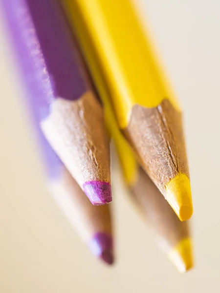 İki renkli kalemin ucu, menekşe ve sarı.