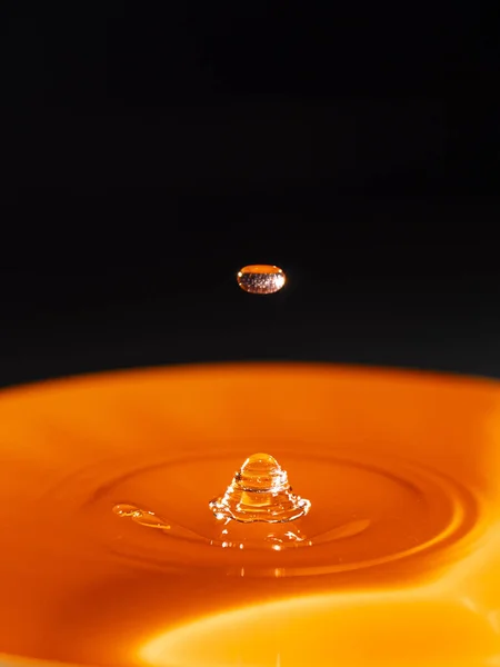 Siyah arkaplanlı turuncu su damlası