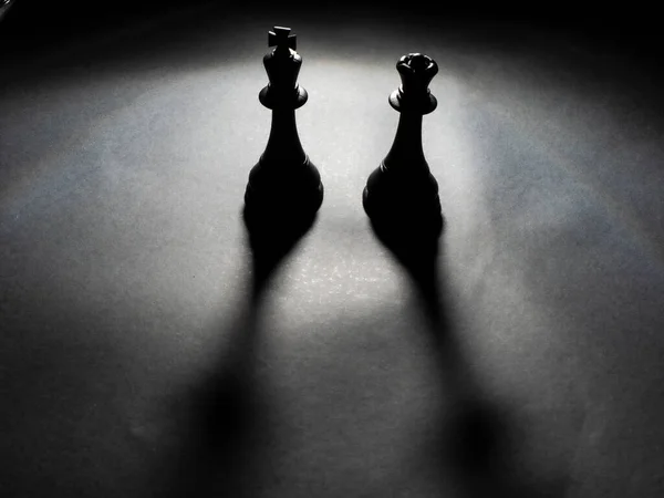 Image of black king and queen chess backlighting with black background