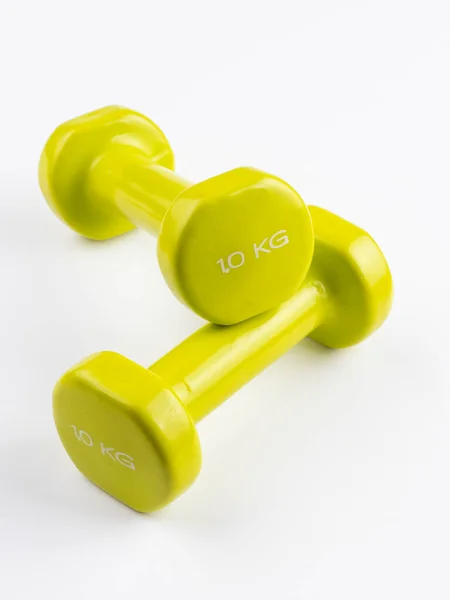 Beyaz arkaplanda iki küçük yeşil kilonun dikey görüntüsü.