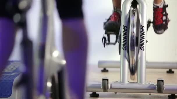 Spinning klass: fötter trampa på motionscyklar — Stockvideo