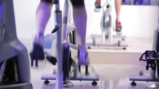 Cours de spinning : pieds pédalant sur des vélos d'appartement — Video