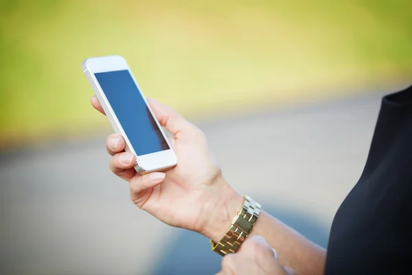 Witte smartphone in de hand van de vrouw — Stockfoto