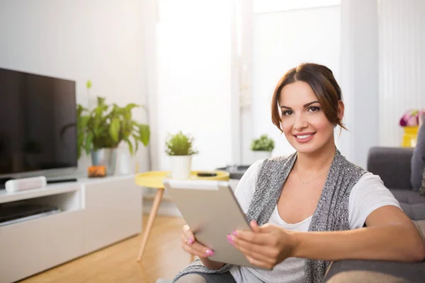 Gelukkige vrouw zittend op de vloer met behulp van Tablet PC — Stockfoto