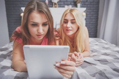 İki kız tablet üzerinde okuma