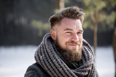 Beyaz ormanda kış ceket giyen gülümseyen bir adam portresi