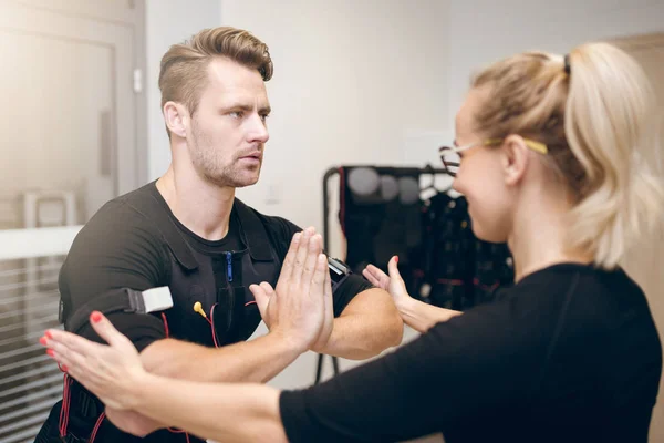 Koncentrerad sportsman i yogaställning träning med tränare — Stockfoto