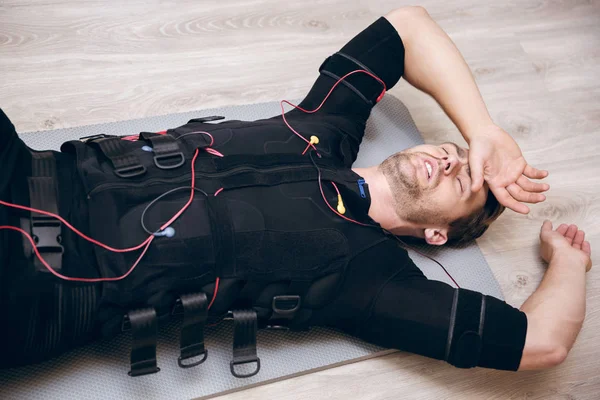 Втомлений спортсмен лежить на підлозі після тренувань з Емі — стокове фото