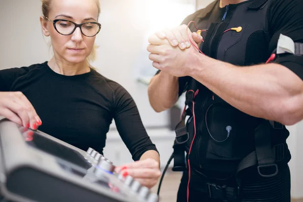 Tränare som ställer in ems-enhet — Stockfoto