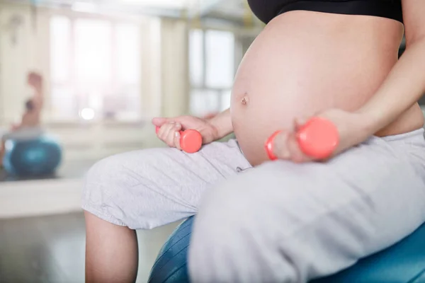 Ağırlık tutan spor salonu topa oturan hamile kadın — Stok fotoğraf