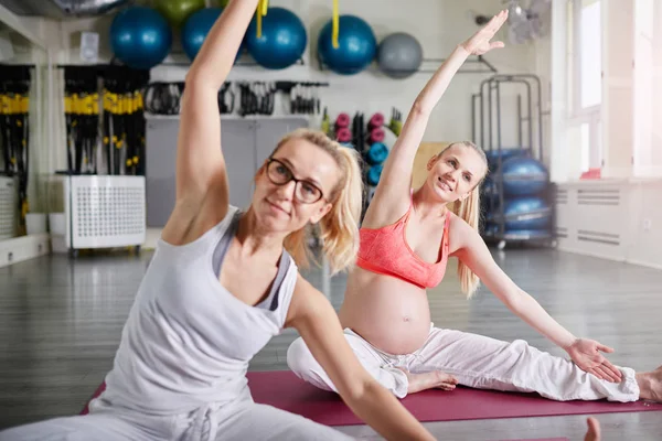 Kişisel antrenör pozuyla yoga yaparken mutlu hamile kadın — Stok fotoğraf