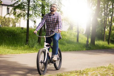 Genç modern insan binicilik bisiklet park düşüncesinde