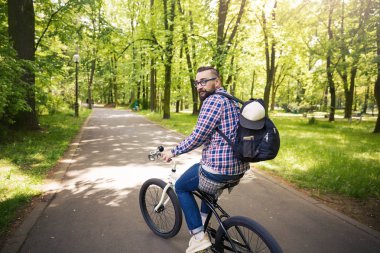 Genç modern insan binicilik bisiklet park sırt çantası ile