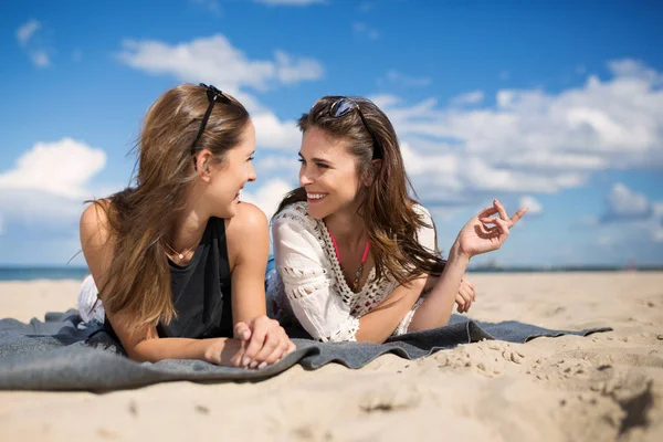 Zwei schöne Freundinnen unterhalten sich am Strand — Stockfoto
