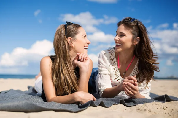 Feliz amigos do sexo feminino relaxando na praia falando — Fotografia de Stock