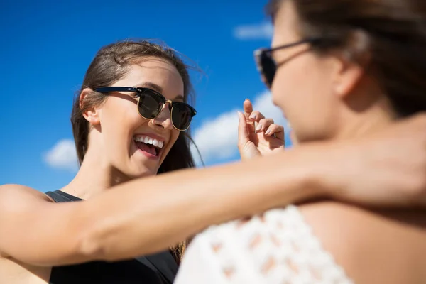 Junge glückliche Frau umarmt Freundin und erzählt ihr etwas — Stockfoto