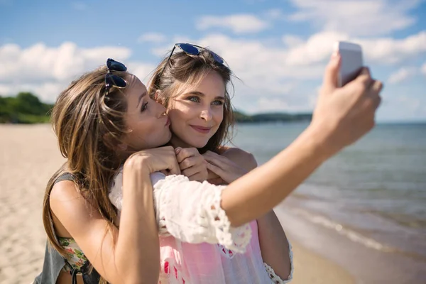 Две красивые подружки делают селфи на пляже, веселятся — стоковое фото