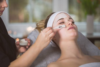  Woman getting enzymatic peeling at beautician's clipart