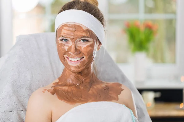 Молодая женщина во время освежающей шоколадной маски в спа — стоковое фото