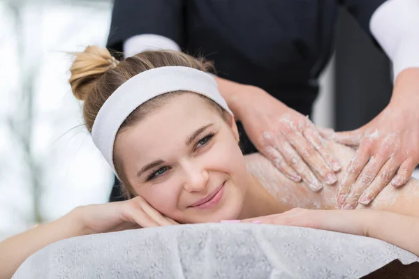 Mulher recebendo massagem esfoliante esfoliante esfoliante no esteticista — Fotografia de Stock