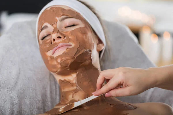女人在水疗中心得到巧克力面膜治疗 — 图库照片