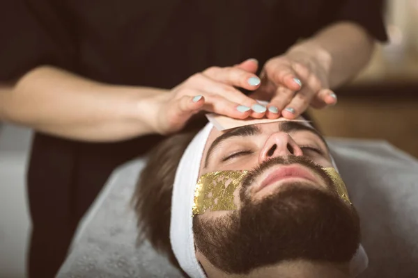 Férfi arany maszk terápia: kozmetikus — Stock Fotó