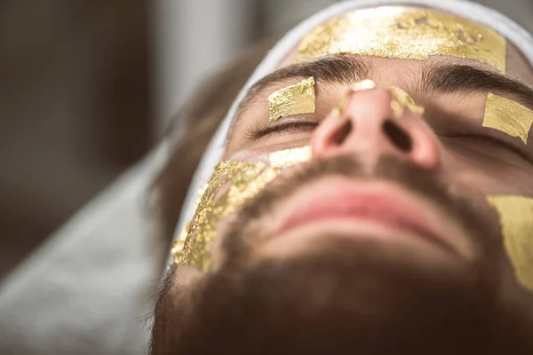 Terapia de máscara dourada masculina no esteticista — Fotografia de Stock