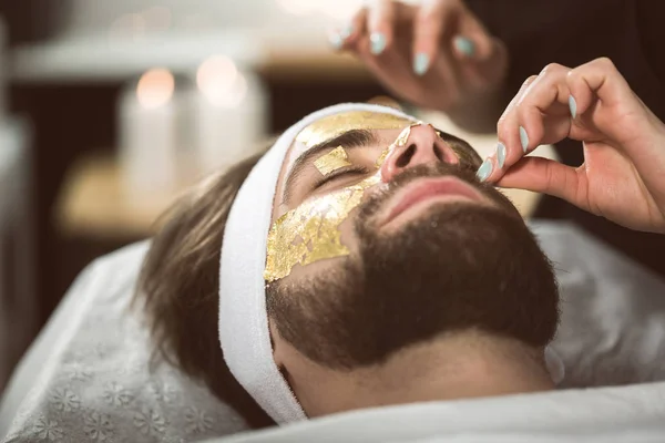在美容师的男装金面具治疗 — 图库照片