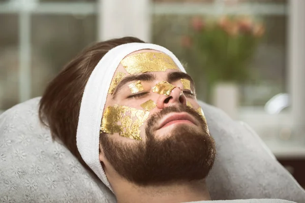 Men's gold mask therapy at beautician's — Stock Photo, Image