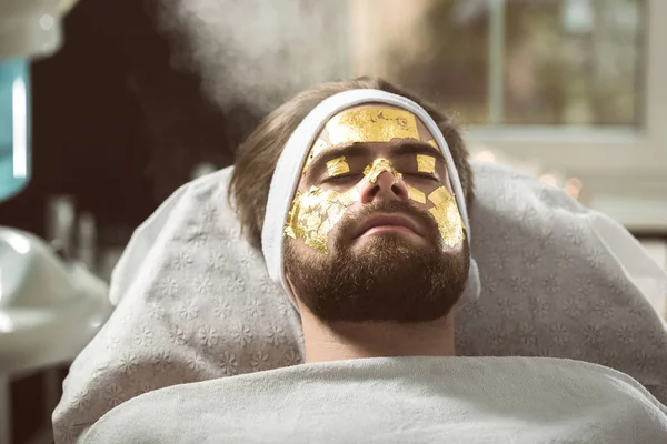 Men's gold mask therapy at beautician's — Stock Photo, Image