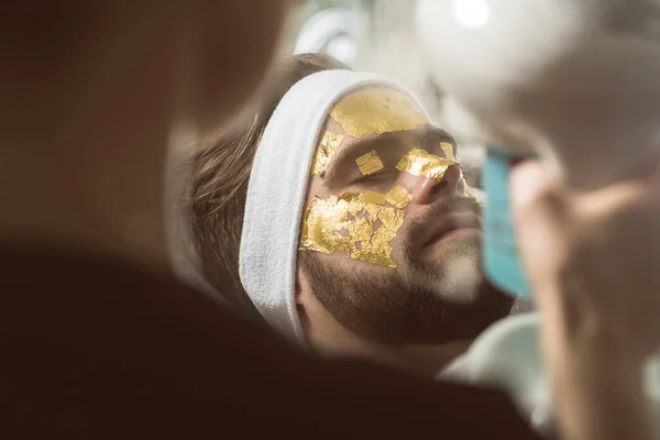 Чоловіча терапія золотою маскою у косметолога — стокове фото