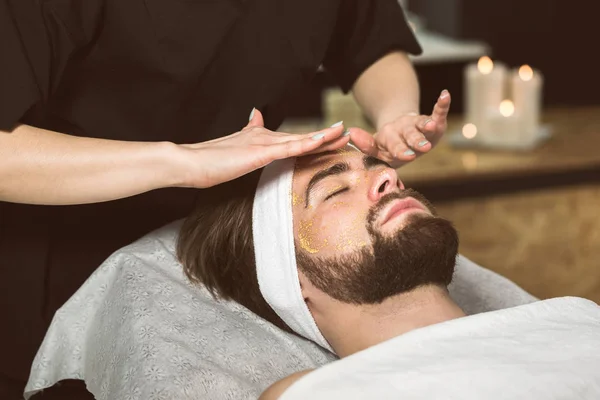 美容師の男性の金のマスク療法 — ストック写真