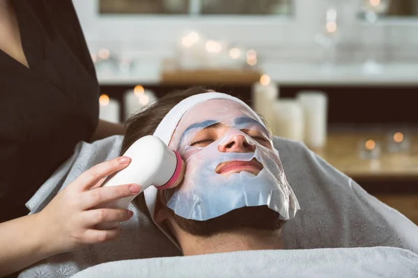 Men's biocellulose mask treatment at spa — Stock Photo, Image