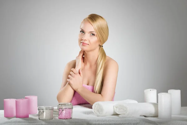 Mulher bonita na toalha atrás da mesa com velas — Fotografia de Stock