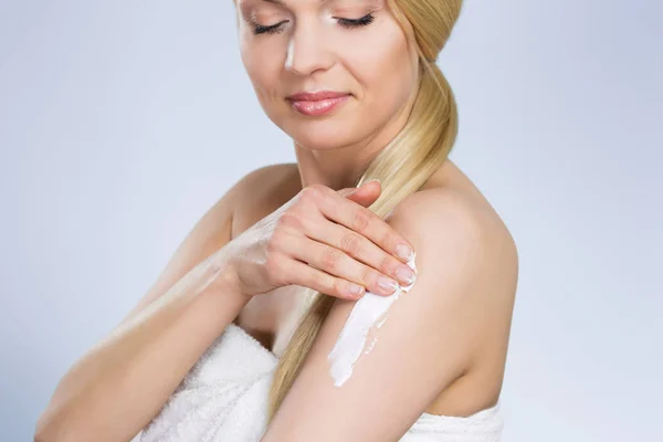 Žena vlhčení její kůže se smetanou — Stock fotografie