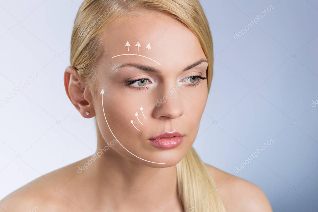 Young beautiful woman with surgical markers on face