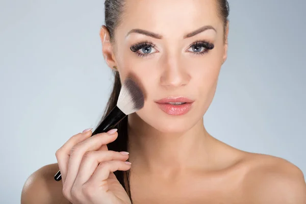 Joven hermosa mujer aplicando polvo facial —  Fotos de Stock