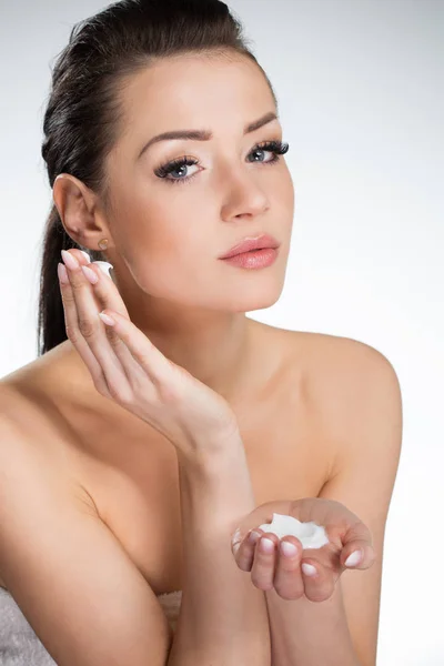 Mujer hermosa clásica aplicando crema en la cara —  Fotos de Stock