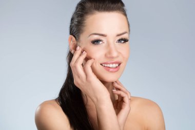 Yüzünü dokunaklı siyah saçlı genç mutlu kadın