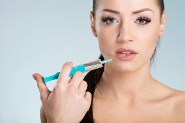 Güzel genç kadın kendini alarak enjeksiyon dudakları