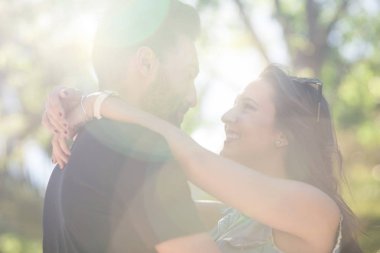 Güneş ışığında kucaklayan aşık genç mutlu çift