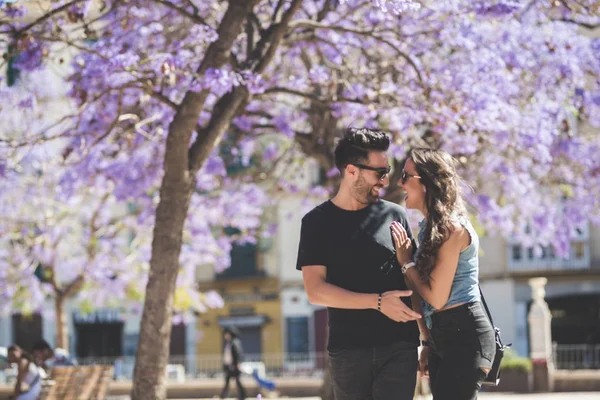 Feliz pareja de pie juntos fuera riendo — Foto de Stock