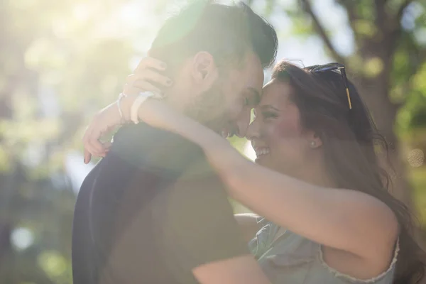 Joven pareja feliz en el amor apoyándose uno en el otro la cabeza en sunligh — Foto de Stock