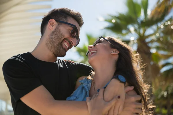 Молодая счастливая пара обнимается и смеется вместе — стоковое фото