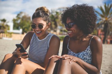 Mobil gülüyor kullanarak sahilde güzel kızlar